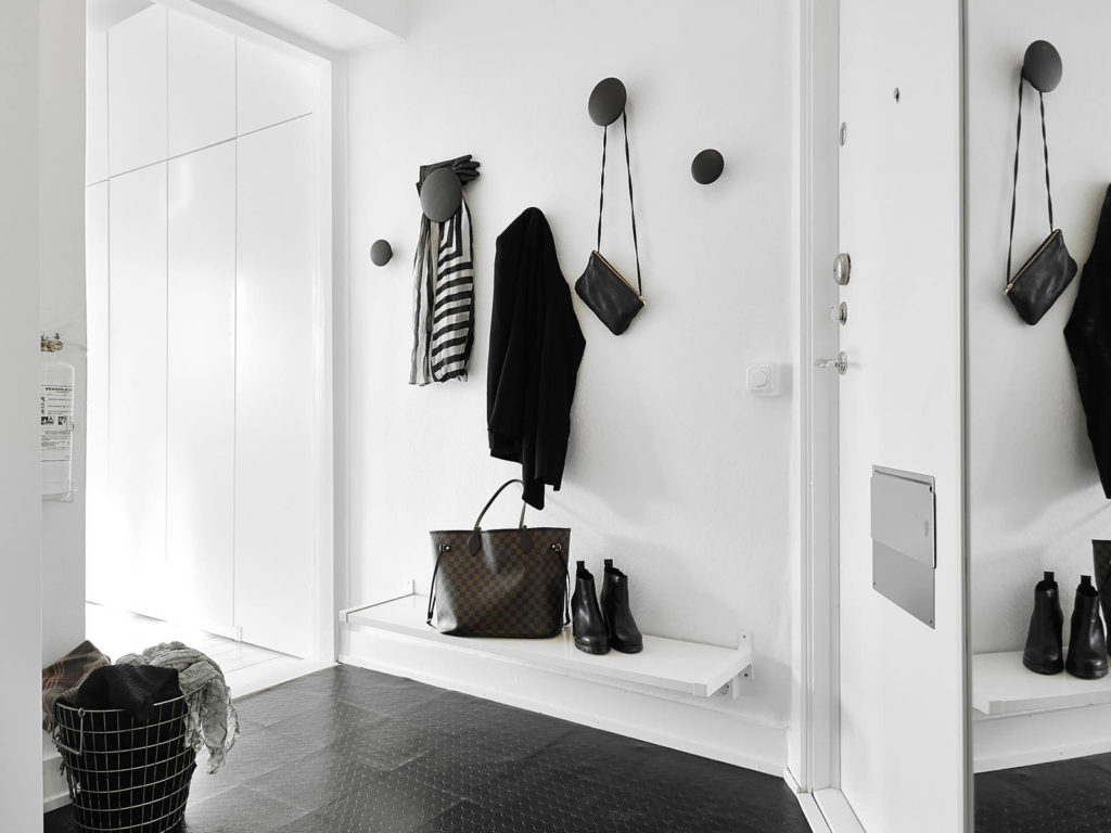 Hooks for outerwear on a white wall of the hallway