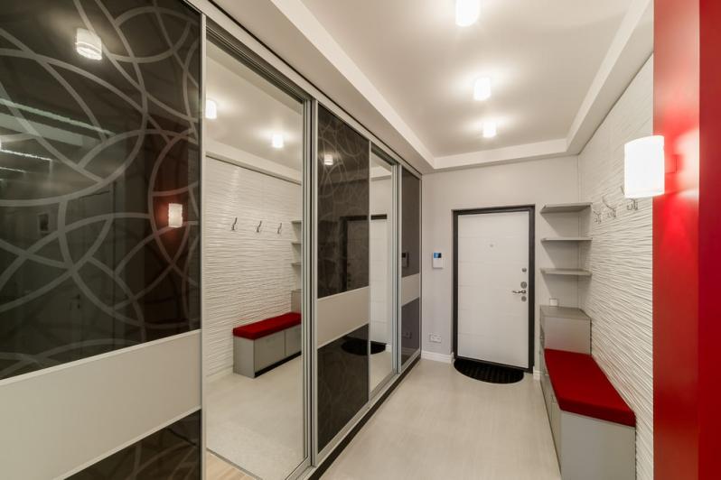 Sliding wardrobe with glass doors in a narrow hallway