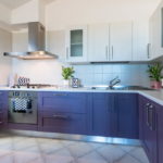 Corner kitchen with purple nightstands.
