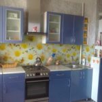 White and blue kitchen with a bright floral apron