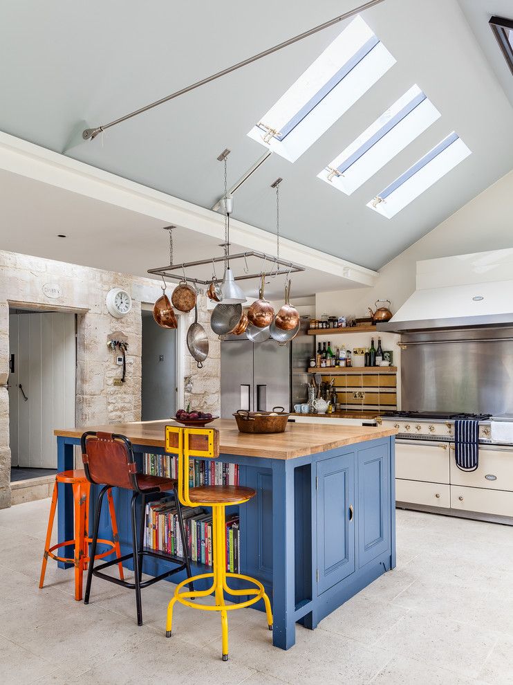 Mavi tavanlı mutfakta zıt renklerde bar tabureleri