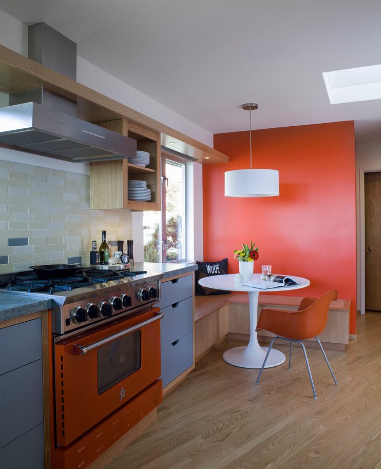 Lamināta koka grīda virtuvē ar oranžu sienu