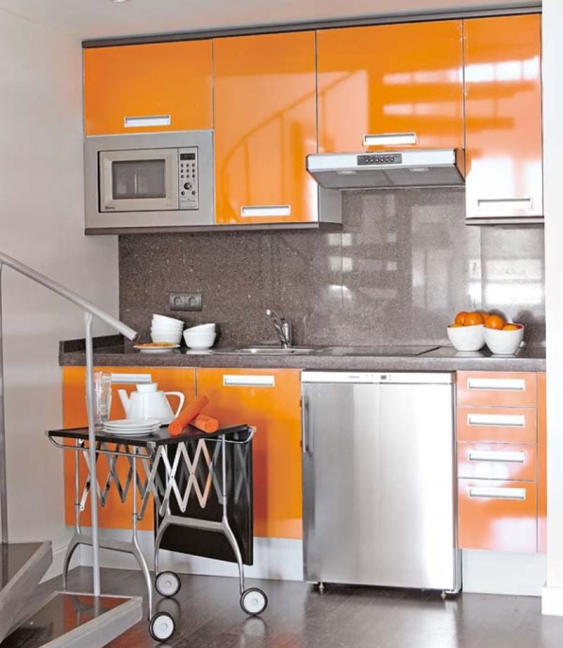 The combination of metallic with an orange tone in the interior of the kitchen