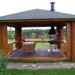 Barbecue en métal dans le gazebo avec plancher en bois.