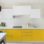 Mobilă galbenă într-o bucătărie albă