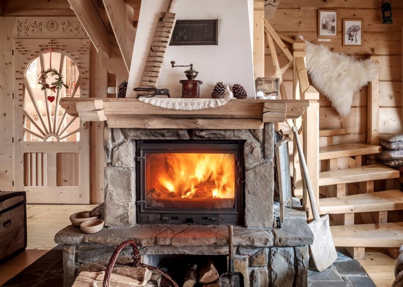 Decoratieve open haard in de keuken-woonkamer in chaletstijl