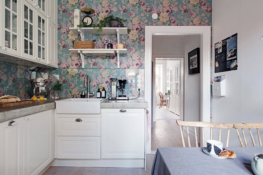 Ziedu tapetes virtuvē ar baltām mēbelēm