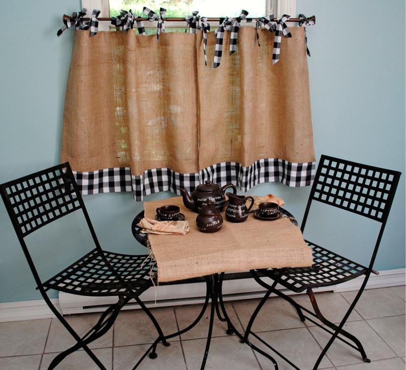 Table de petit déjeuner devant la fenêtre de la cuisine avec un court rideau