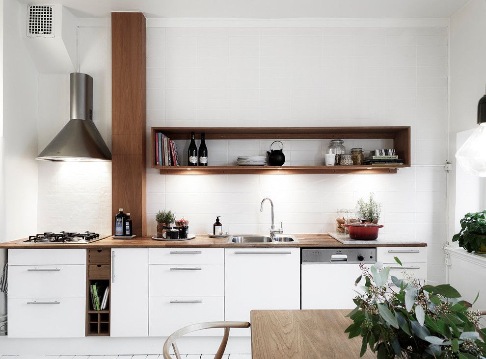 Houten plank in plaats van wandkasten in de Scandinavische keuken