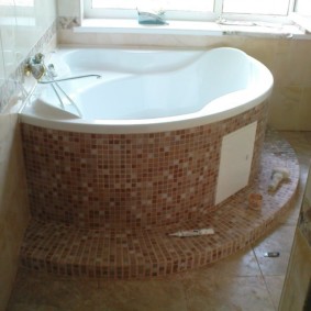 Pedestal corner bathtub with ceramic cladding