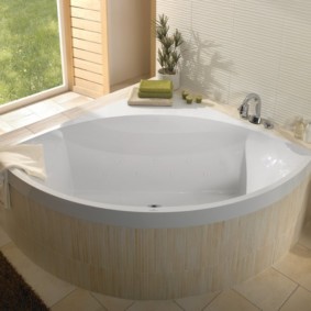 Acrylic corner bathtub in front of a window in a private house