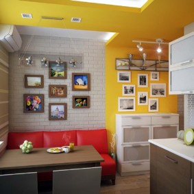 Sarkans dīvāns virtuvē ar dzeltenām sienām
