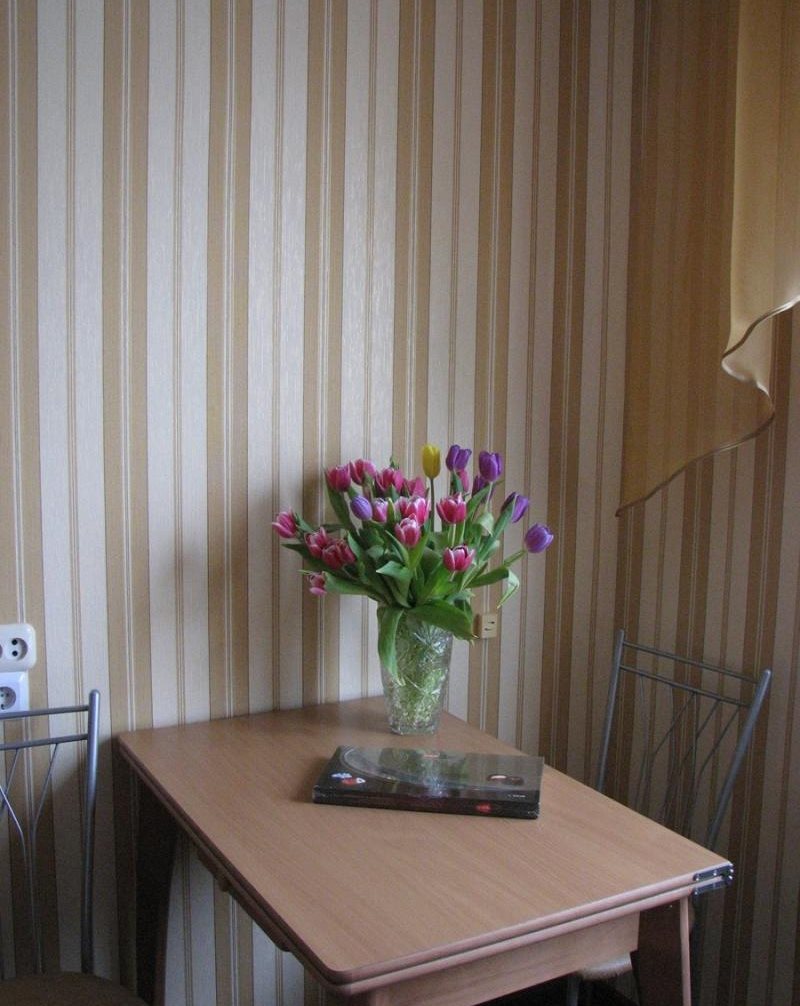 Spisebord ved veggen med stripete tapet
