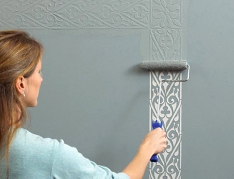 Izmantojot trafaretu, uz sienas uzzīmējiet dekoratīvu krāsas slāni