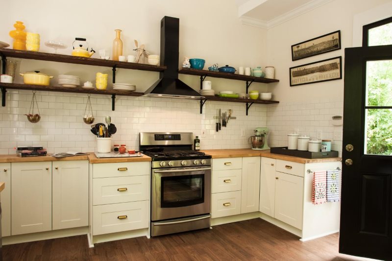 Open shelves on a white kitchen wall