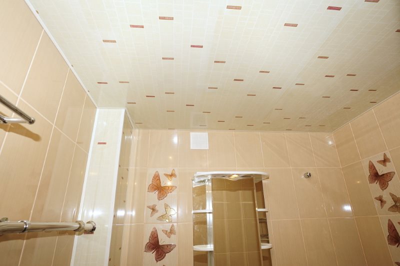A fürdőszoba falának burkolata bézs PVC panelekkel