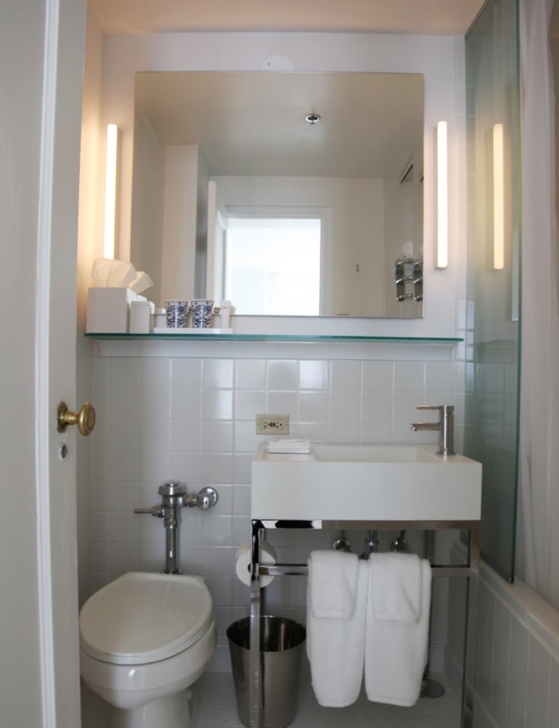 Lite toalett med et stort speil på veggen