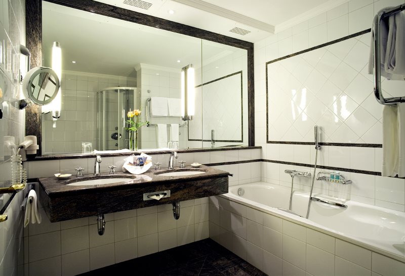 Stort speil på veggen i et lite badekar