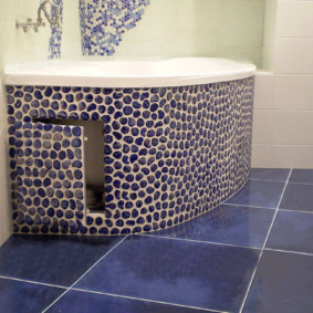 Puerta con mosaico en el revestimiento del baño.