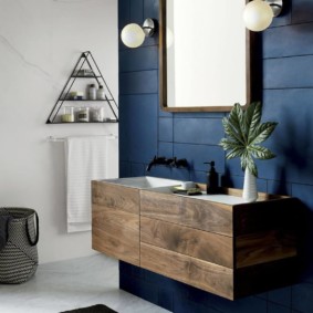 Mavi duvarlı banyoda ahşap dolap