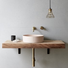 Mặt bàn bằng gỗ trong phòng tắm với những bức tường màu xám.