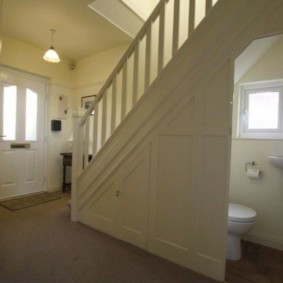 Open door to the toilet under the stairs
