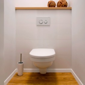 Houten plank boven een scharnierend toilet