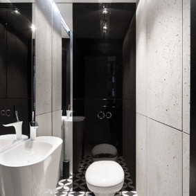 Hvitt toalett på en svart vegg