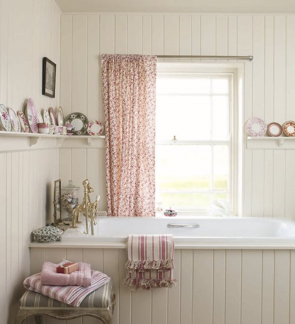 Et farverigt gardin på badeværelsesvinduet i stil med lurvet chic