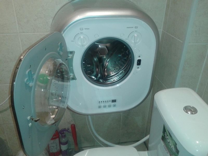 Kompakt tvättmaskin på väggen i badrummet