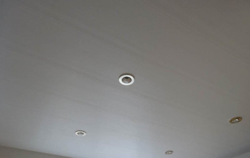 Inbouwarmaturen op het matte plafond in de badkamer