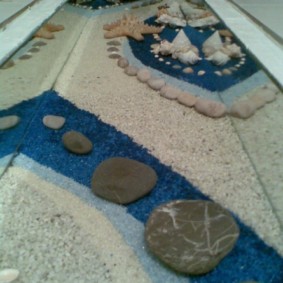 Batu-batu dan pasir di bawah salutan epoksi di lantai pukal