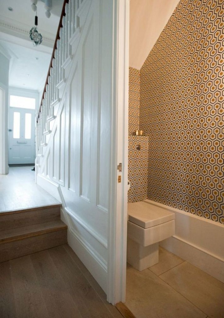 Square toilet in the room with wallpaper on the walls