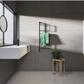 Minimālistiska pelēka flīze uz vannas istabas sienas