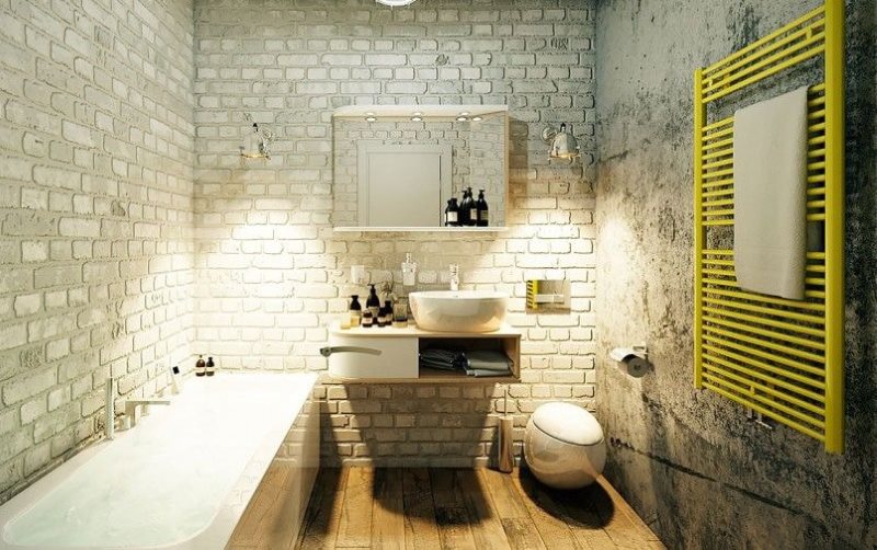 Yellow heated towel rail in a loft style bathroom