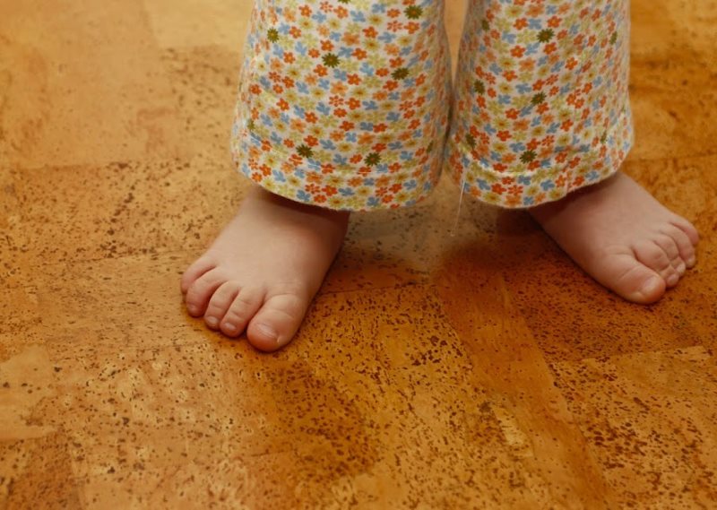 Kleine baby op kurkvloer in de badkamer