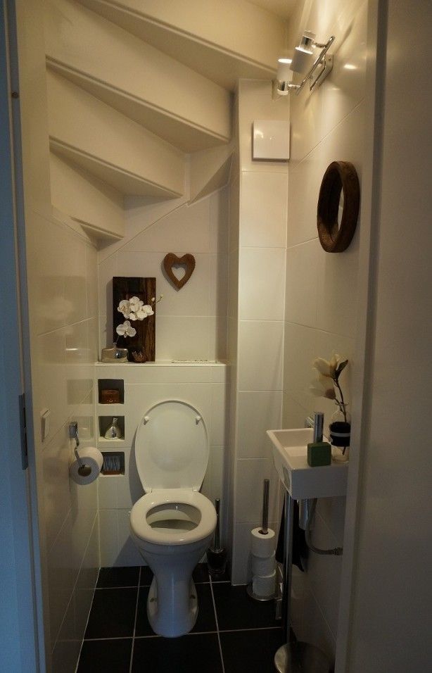 Toaleta interioară sub o scară în spirală