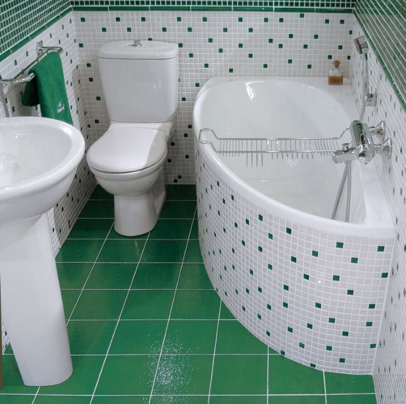 Zaļas flīzes uz nelielas vannas istabas grīdas