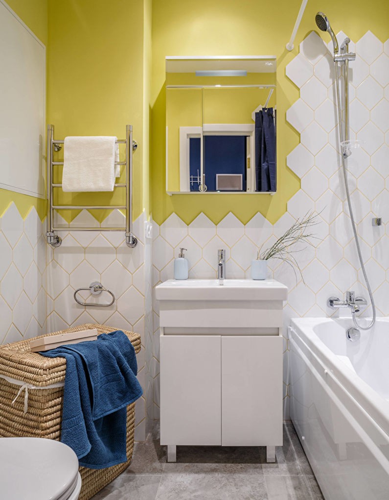 Dzeltenas sienas baltā flīzētā vannas istabā