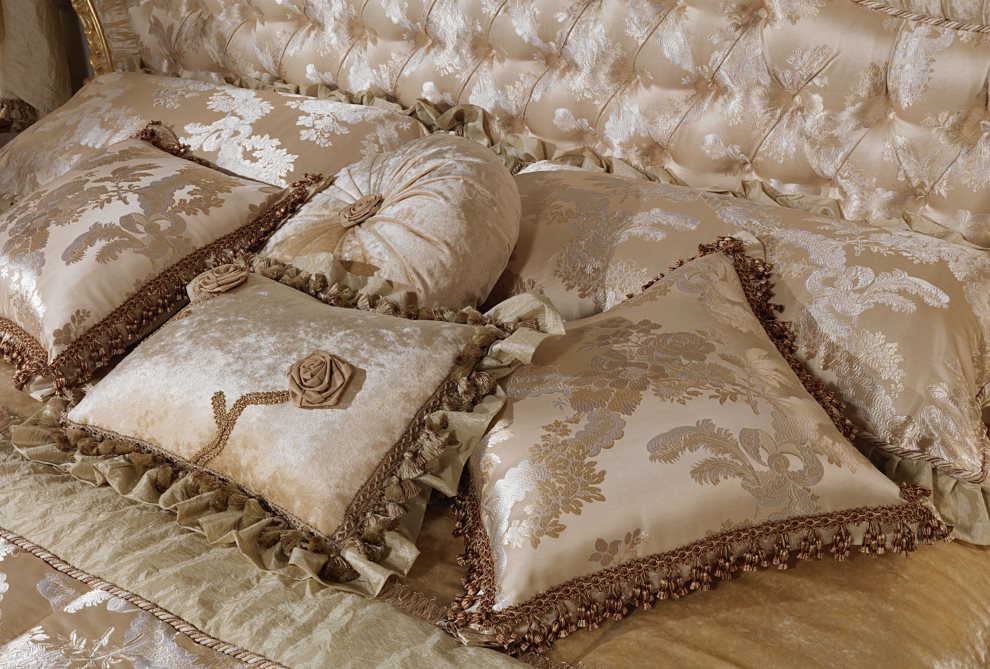 Baroka stila satīna spilveni uz gultas