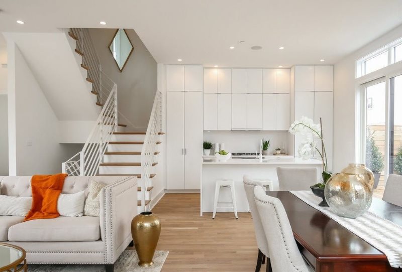 Kök-vardagsrum med trappor till andra våningen i ett privat hus