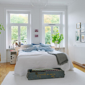 phòng ngủ màu trắng với một chiếc giường bên cửa sổ