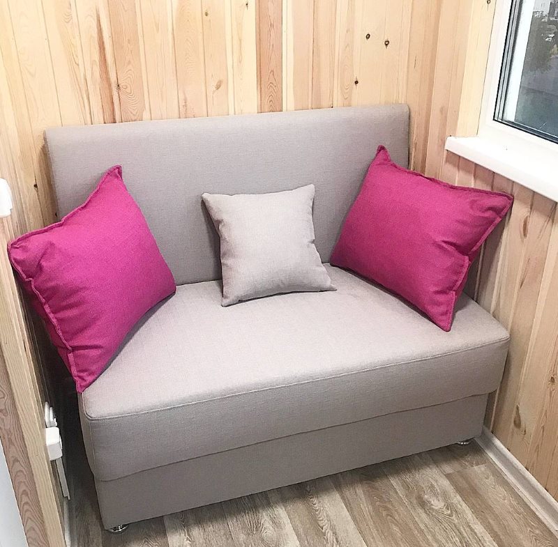 Pilka sofa balkone su medine apmušalais