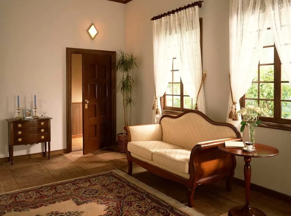 Kanapé egy fából készült keretben egy szobában, világos függönyökkel