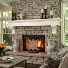 Stone fireplace between the windows in a country house