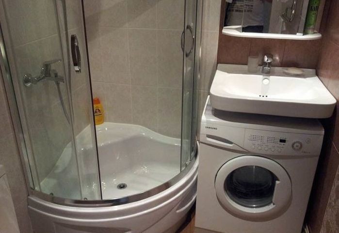 Cabină de colț într-o baie mică cu o mașină de spălat