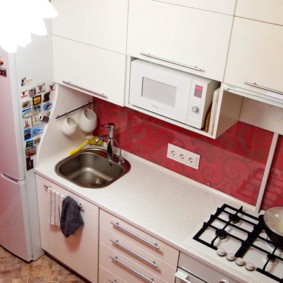 Mosogató a hűtőszekrény közelében egy kis konyhában