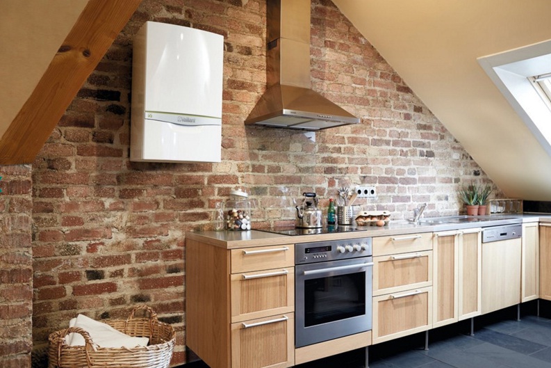 White cauldron on the brick wall of the kitchen in the loft style