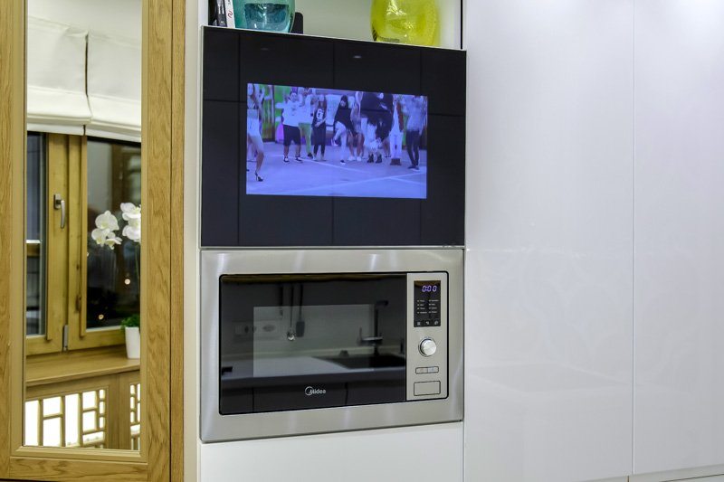 mikrobangų krosnelė virtuvėje su televizoriumi