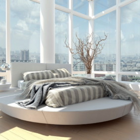 bedroom with a round bed by the window